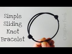 a hand holding a black string bracelet with the words simple sliding knot bracelet