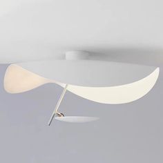 a white ceiling light hanging from the ceiling in a room with grey walls and flooring