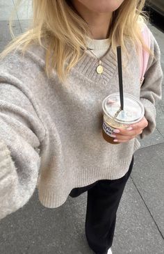 a woman holding a cup of coffee in her right hand