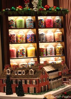 an assortment of candies and candy displayed in front of a display case with christmas decorations