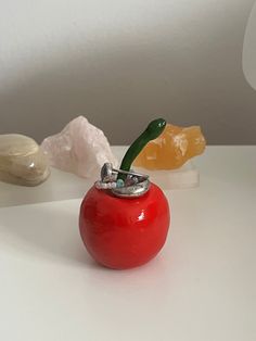 a red apple sitting on top of a white table