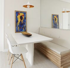 a white dining table with two chairs and a bench in front of the mirror on the wall