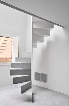 an empty room with white walls and stairs