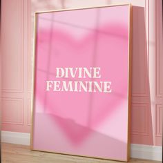 a pink poster with the words divine feminine on it in front of a pink wall