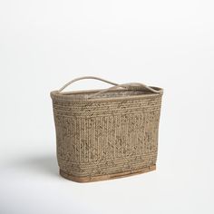 a large woven basket with handles on the top and bottom, sitting in front of a white background