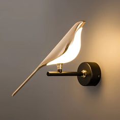 a wall mounted light with a bird on it