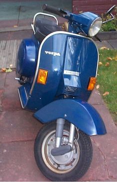 a blue scooter is parked on the sidewalk