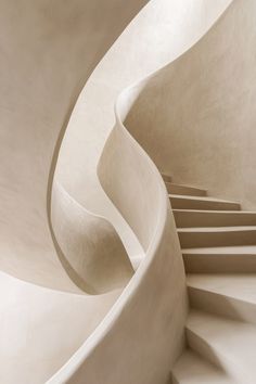 a spiral staircase in a building with white walls