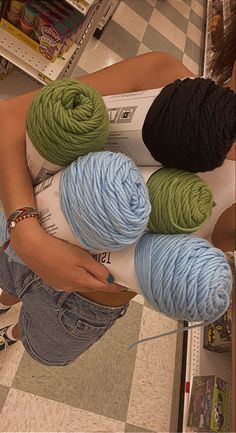 three balls of yarn sitting on top of each other in front of a store counter