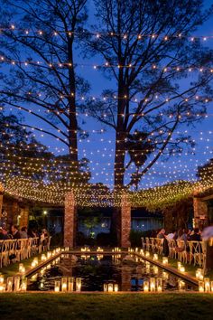 an outdoor venue with lit candles and trees