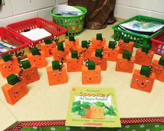 a table with many orange bags on top of it and a book in front of them