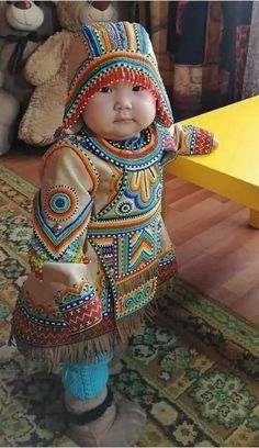 a baby doll is dressed in colorful clothing