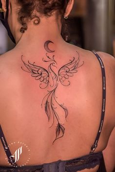 the back of a woman's neck with an angel tattoo on her left side