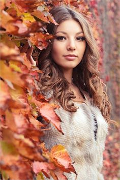 a woman standing in front of some leaves