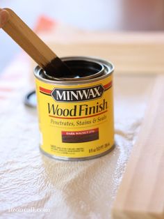 a can of minwax wood finish sitting on a table with a wooden stick sticking out of it