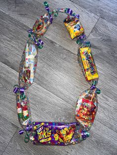 an assortment of gummy bears and candy on a wooden floor, with the top half wrapped in cellophane