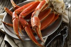 two crabs on a plate next to silverware and utensils