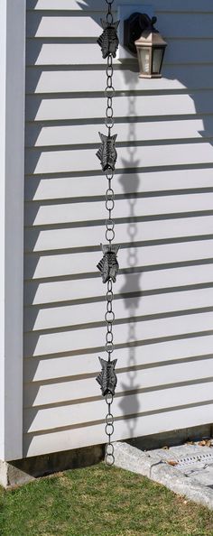 a metal chain is attached to the side of a house with a light on it