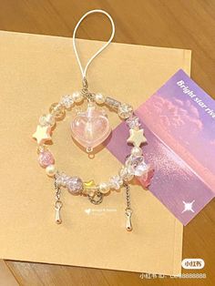 a bracelet with charms on it sitting next to a card