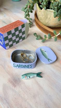 there is a box with two rings in it and some fish on the table next to it