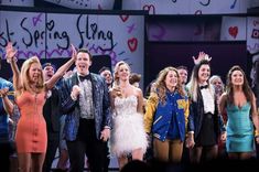 a group of people standing on top of a stage with their hands in the air