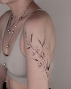 a woman with a flower tattoo on her left arm and right arm behind her back