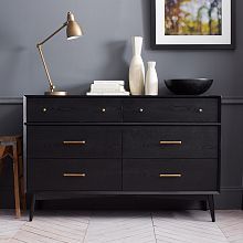 a black dresser with two vases and a lamp on top