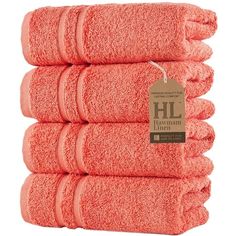 six orange towels stacked on top of each other in front of a white background with a tag