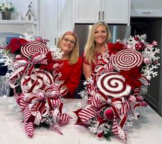 two women standing next to each other holding candy canes