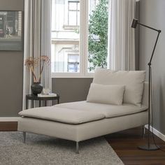 a white chaise lounge chair sitting in front of a window