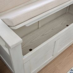 a white bench sitting on top of a hard wood floor