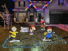 christmas decorations in front of a house decorated with peanuts and charlie the pooh characters