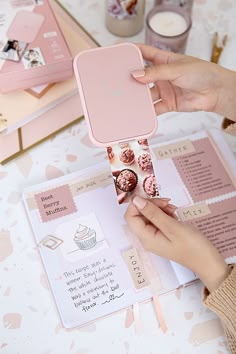 a person holding up a pink phone case with cupcakes on it and other items