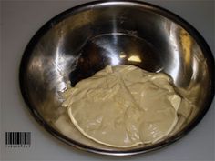 a metal bowl filled with batter on top of a counter