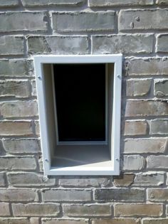 an open window on the side of a brick wall with no glass in it,