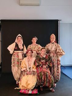 a group of women in traditional dress posing for a photo