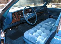 the interior of an old car with blue upholstered seats and dash board covers