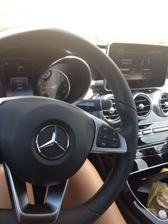 the steering wheel and dashboard of a mercedes c - class sedan with black leather trim