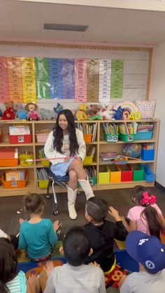 a woman sitting in front of a group of children