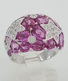 You are purchasing a 12.14 ct total weight 18k White Gold Pink Sapphire & Diamond Cocktail / Statement Ring. The ring weighs 12.5 grams, size 6.75 (fits finger size 6.25-6.75 due to the width), there are 20 Natural Pink Sapphires weighing ~11.63 ct & 36 Natural Round Brilliant Cut diamonds weighing ~0.51 ct, G-H in color, VS-SI in clarity. The ring is stamped "750 18K" "11.63" & "D0.51" for the weight of the sapphires & diamonds. The retail price for this ring is $7,500. Comes with a wood ring box. Please follow us on Instagram for more unique items & specials: Exquisite_Jewelers_Inc ~The ring can be seen in person at Exquisite Jewelers in Palatine, IL * 847 * 202 * 7889~ Diamond Ring Setting Sapphire/Diamond Total Weight 11.63 ct / 0.51 ct Stones Cut Oval / Round Color Pink / G-H Clarity Wood Ring Box, Statement Rings Diamond, Diamond Ring Settings, Wood Rings, Beaded Rings, Sapphire Diamond, Round Brilliant Cut Diamond, Ring Box, Round Brilliant Cut