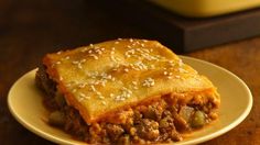 a close up of a plate of food with meat and cheese on it, sitting on a table