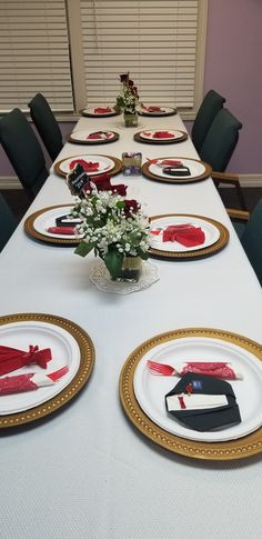 the table is set with plates and place settings for formal dinner guests to sit at