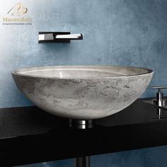 a white bowl sink sitting on top of a black counter