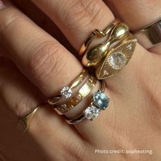 a woman's hand with three different rings on it