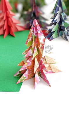 folded paper christmas trees sitting on top of a table