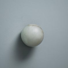 an onion is hanging on the wall in front of a gray wall with white paint