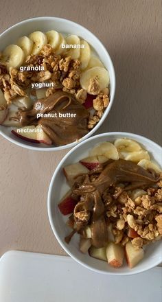 two bowls filled with granola, yogurt, peanut butter and apples on top of a table