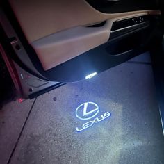 the inside of a car with its door open and lights on, showing the logo