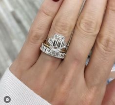 a woman's hand with two rings and a diamond ring on top of her finger