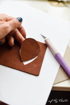 a person is cutting out a heart with a sharpie on a piece of paper